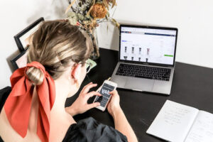 chica comprando en su celular y laptop